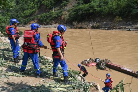 (miniature) Des sauveteurs travaillent sur le cours inférieur de la rivière près du site de l'effondrement d'un pont dans le district de Zhashui
