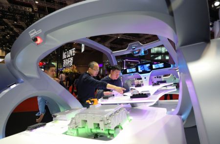 (miniature) Des visiteurs examinent des modèles d'appareils électroniques embarqués exposés sur le stand de Bosch lors de la 20e édition du Salon international de l'industrie automobile de Shanghai (Auto Shanghai)