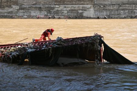 (miniature) Un sauveteur travaille sur le cours inférieur de la rivière près du site de l'effondrement d'un pont dans le district de Zhashui