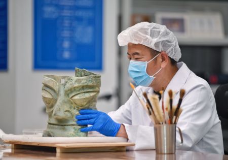 (miniature) Guo Hanzhong nettoie un masque de bronze au musée de Sanxingdui de la ville de Guanghan