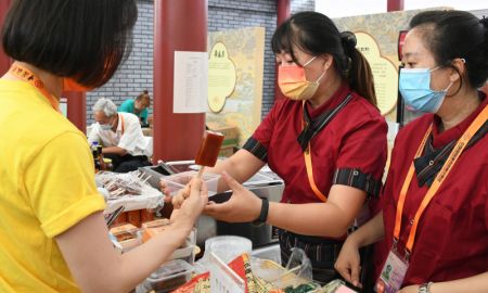 (miniature) Une visiteure achète de la nourriture lors du Salon international du commerce des services de Chine (CIFTIS) 2021