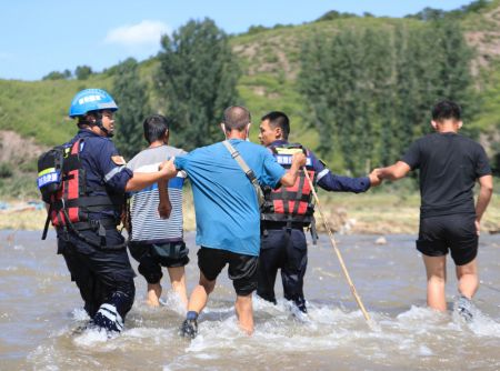 (miniature) Des membres de l'équipe de secours évacuent des résidents affectés dans le bourg de Heishanke de la ville de Huludao