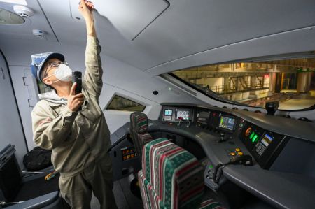 (miniature) Un technicien inspecte la cabine de conduite d'un train à grande vitesse dans un centre de maintenance d'Urumqi