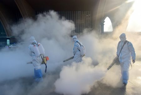 (miniature) Des membres du personnel désinfectent la place ouest de la gare de Shijiazhuang