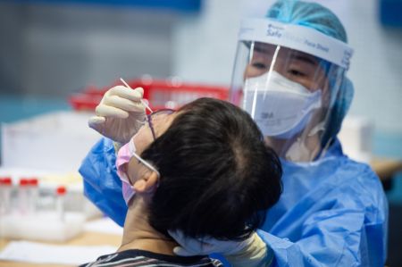 (miniature) Une professionnelle médicale effectue un prélèvement nasal sur une habitante pour le test d'acide nucléique à Macao