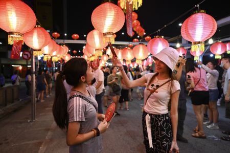 (miniature) Des festivaliers jouent aux devinettes inscrites sur les lanternes lors d'une célébration du Nouvel An chinois à George Town dans l'Etat de Penang
