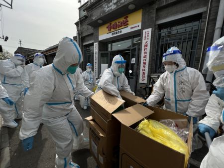 (miniature) Des travailleurs de quartier transportent du mat&eacute;riel m&eacute;dical dans l'arrondissement de Xicheng