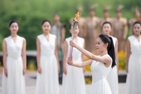 (miniature) Une femme présente la flamme lors de la cérémonie d'allumage de la flamme des Jeux asiatiques 2022 de Hangzhou