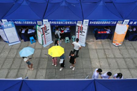 (miniature) Des diplômés d'université lisent des informations sur le recrutement lors d'un salon de l'emploi dans la préfecture autonome Miao et Dong de Qiandongnan