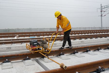 (miniature) Un ouvrier pose des rails sur le chantier de construction du chemin de fer interurbain Beijing-Xiongan dans la Nouvelle Zone de Xiongan