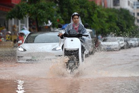 (miniature) Une habitante en scooter dans une rue inondée de Nanning