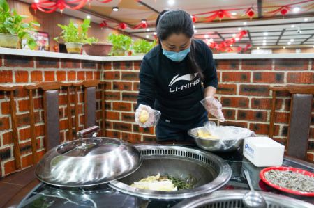 (miniature) La villageoise Yu Shufen prépare un repas pour les clients dans l'installation d'agritourisme qu'elle dirige près de la Station de ski de Beidahu