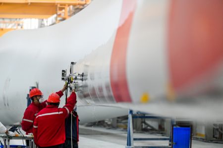 (miniature) Des employés travaillent sur une ligne de production de pales d'éoliennes dans une entreprise du secteur énergétique à Ulaan Chab