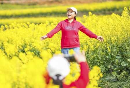 (miniature) Une touriste pose pour des photos dans un champ de fleurs de colza