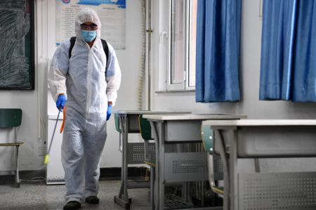 (miniature) Un employé désinfecte une salle de classe d'une école secondaire à Tianjin