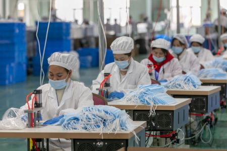 (miniature) Des travailleurs produisent des masques de protection dans une usine de masques de Threegun Group