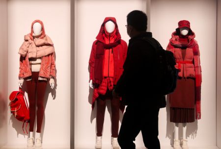 (miniature) Un visiteur passe devant le stand de la marque de vêtements de loisirs Uniqlo dans la zone d'exposition des biens de consommation lors de la 3e édition de l'Exposition internationale d'importation de la Chine (CIIE) à Shanghai