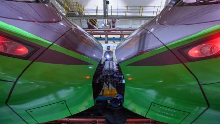 (miniature) Un technicien inspecte un train à grande vitesse dans un centre de maintenance d'Urumqi