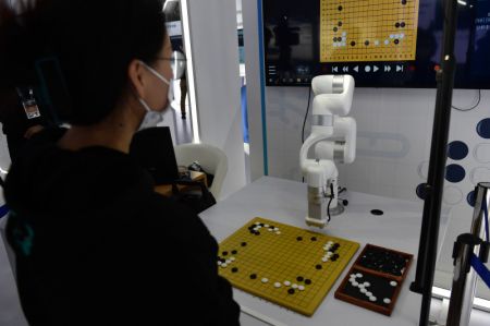 (miniature) Une visiteuse joue au jeu de go avec un robot à la 4e édition de la Convention mondiale du secteur manufacturier