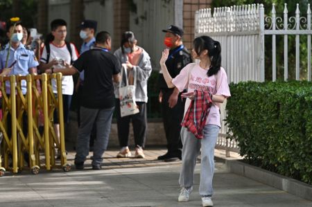 (miniature) Une candidate salue les membres de sa famille à l'extérieur d'un site d'examen au lycée expérimental rattaché à l'Université normale de Beijing