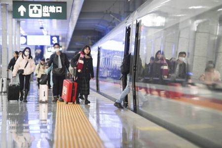 (miniature) Des passagers montent à bord d'un train à la gare de Shapingba