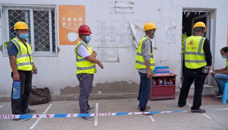 (miniature) Des ouvriers font la queue dans un site de prélèvement temporaire dans l'arrondissement de Daxing