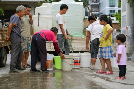 (miniature) Des volontaires remettent de l'eau aux villageois du bourg de Qiaojia