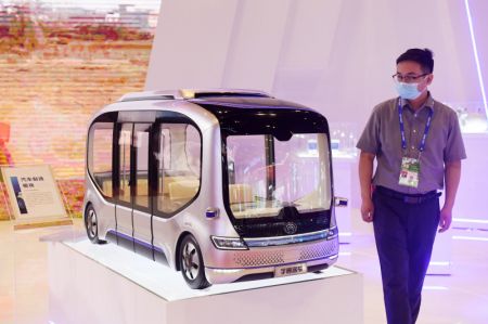 (miniature) Un visiteur regarde un mod&egrave;le r&eacute;duit d'un bus autonome &agrave; la 19e Exposition Chine-ASEAN