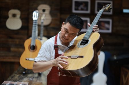 (miniature) Un travailleur contr&ocirc;le une guitare dans le Parc industriel de guitares de Zheng'an