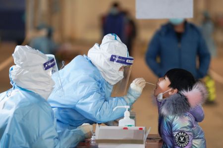 (miniature) Un travailleur médical prélève un échantillon sur un enfant dans un site de dépistage du COVID-19 de l'arrondissement de Daxing