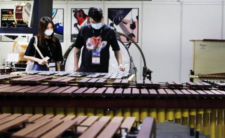 (miniature) Des visiteurs essaient un instrument de percussion lors du salon Music China 2020