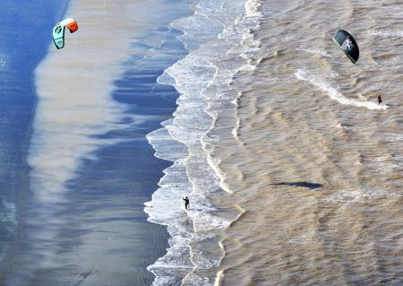 (miniature) Photo aérienne de touristes faisant du kitesurf sur une plage de Qidong