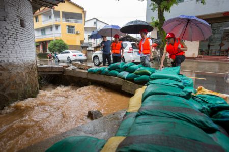 (miniature) Des secouristes inspectent les inondations dans un canal de drainage du village de Hongxing