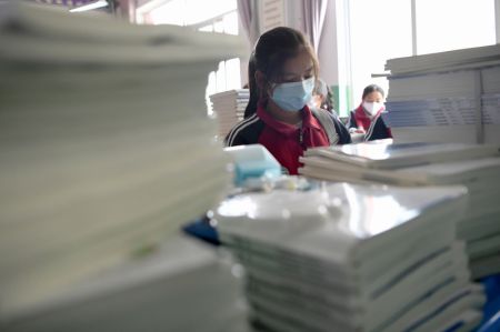 (miniature) Une élève range ses manuels scolaires dans le Collège tibétain de Luqu