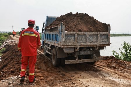 (miniature) Des secouristes transportent des matériaux de construction pour renforcer une digue récemment réparée à Tieling