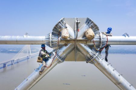 (miniature) Des techniciens sur le chantier du projet de transmission d'électricité à ultra-haute tension Baihetan-Zhejiang près du fleuve Yangtsé