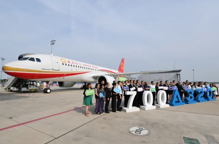 (miniature) Les invités posent pour une photo de groupe lors d'une cérémonie de livraison du 700e avion de la famille Airbus A320 à la compagnie Chengdu Airlines devant un avion A320neo