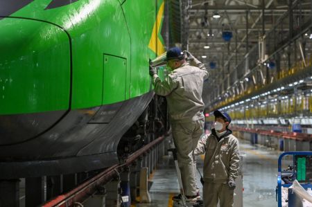 (miniature) Des techniciens procèdent à l'entretien d'un train à grande vitesse dans un centre de maintenance d'Urumqi