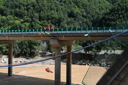 (miniature) Des secouristes travaillent sur le site de l'effondrement d'un pont dans le district de Zhashui de la ville de Shangluo