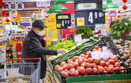 (miniature) Un habitant achète des légumes dans un supermarché à Xi'an