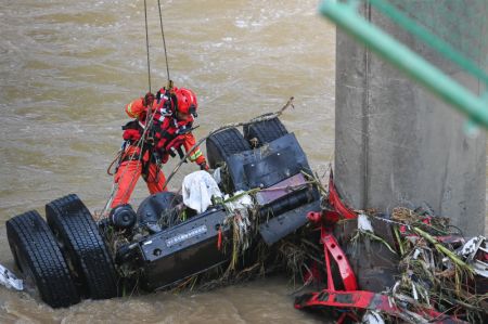 (miniature) Un sauveteur travaille sur le site de l'effondrement d'un pont dans le district de Zhashui