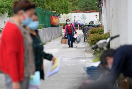 (miniature) Une villageoise retourne chez elle depuis le site de quarantaine dans le village de Lianqin du bourg de Beicai