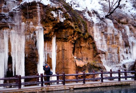 (miniature) Un visiteur prend des photos de chutes d'eau gelée de la montagne de Yuntai