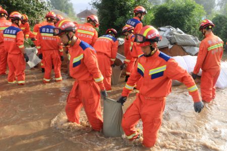 (miniature) Des pompiers d&eacute;placent des sacs de sable dans le district de Yangming &agrave; Mudanjiang