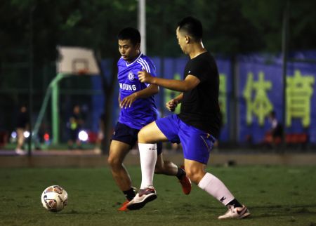 (miniature) Des gens jouent au football sur le terrain de football de la place Guangming