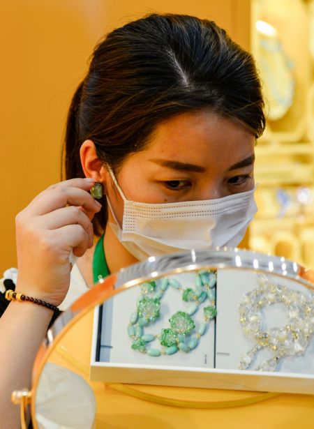 (miniature) Une visiteuse essaie une boucle d'oreille à la première Exposition internationale des produits de consommation de Chine