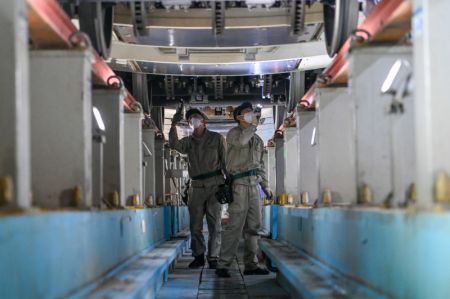 (miniature) Des techniciens procèdent à l'entretien d'un train à grande vitesse dans un centre de maintenance d'Urumqi