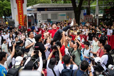 (miniature) Des candidats et leurs enseignants célèbrent devant un site d'examen du concours national d'entrée à l'université à Changsha