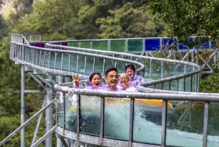 (miniature) Des touristes s'amusent sur un toboggan à fond de verre dans le Grand Canyon de Nanjiang