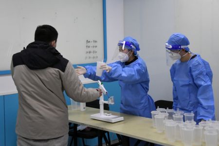 (miniature) Des professionnels médicaux préparent une dose de vaccin inhalable contre la COVID-19 pour un habitant sur un site de vaccination